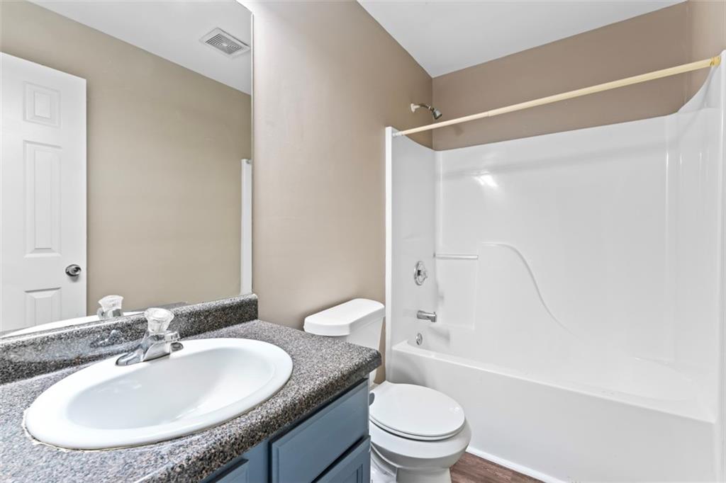 930 Hall Street Northwest, Unit A Atlanta, GA 30318 - Photo 14 of 31 a bathroom with a granite countertop sink mirror toilet and bathtub