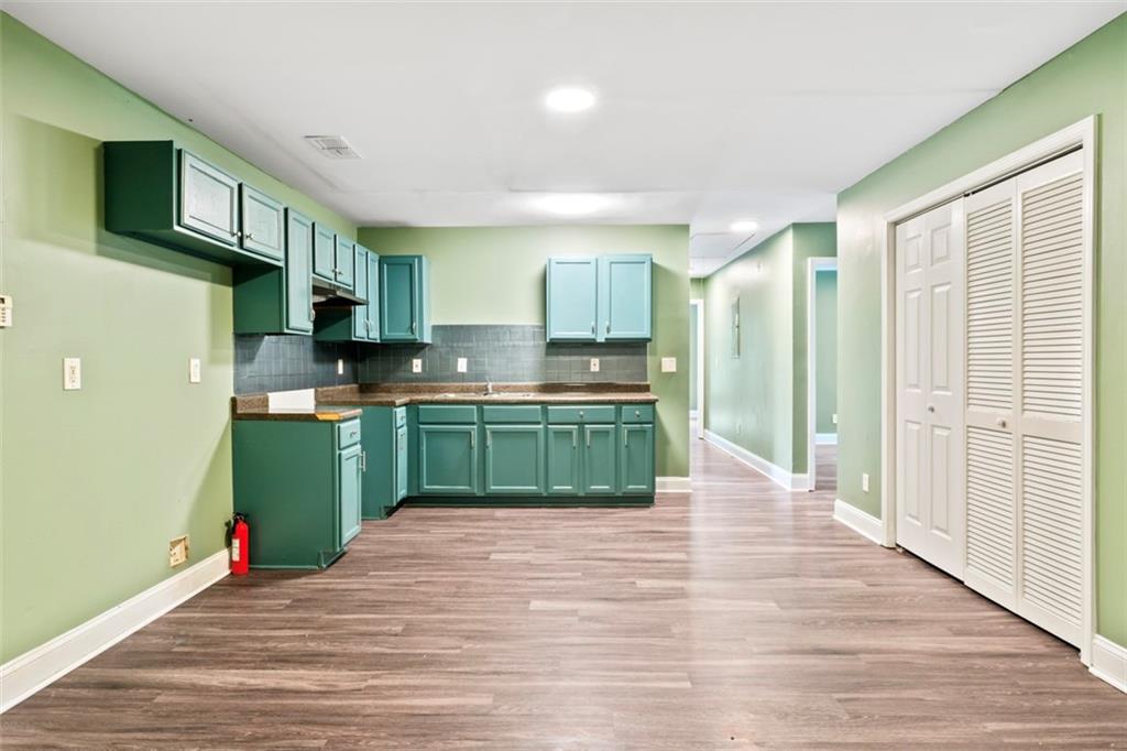 930 Hall Street Northwest, Unit A Atlanta, GA 30318 - Photo 21 of 31 a kitchen with stainless steel appliances granite countertop a refrigerator a sink dishwasher and a wooden floor