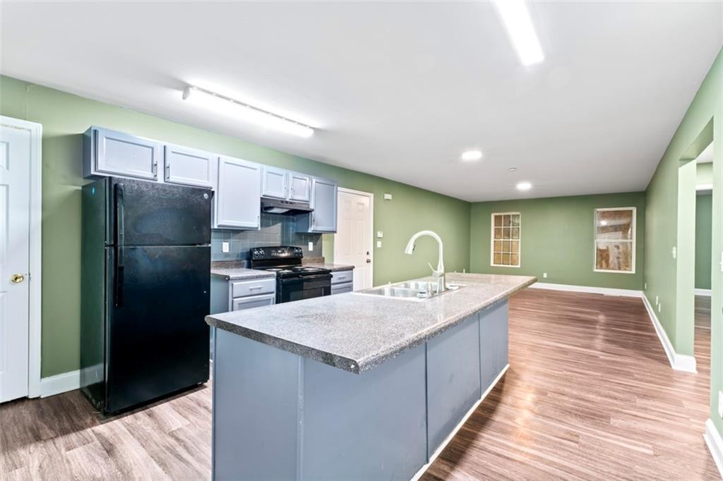 930 Hall Street Northwest, Unit A Atlanta, GA 30318 - Photo 10 of 31 a large kitchen with a center island wooden floor stainless steel appliances and cabinets