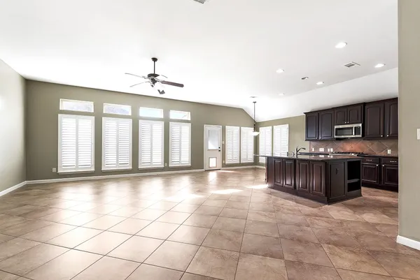 a large kitchen with stainless steel appliances a stove a sink a microwave and cabinets