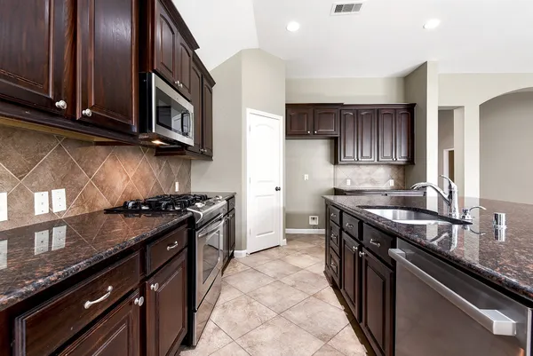 a kitchen with granite countertop stainless steel appliances and wooden cabinets