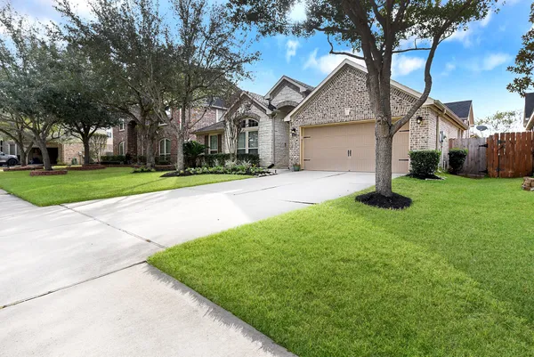 a front view of a house with a yard and trees