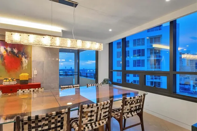 a living room with furniture kitchen view and large windows