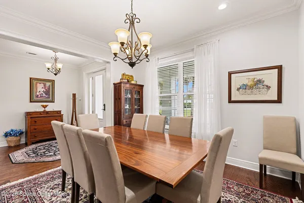 a living room with furniture a wooden floor and a chandelier