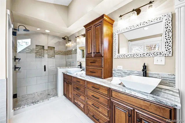 a bathroom with a granite countertop sink mirror and shower