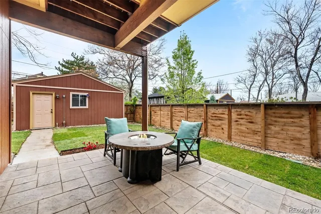 a view of a chairs and table in the back yard of the house