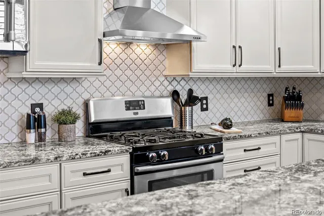 a kitchen with granite countertop a stove sink and cabinets