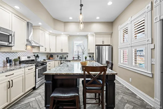 a kitchen with stainless steel appliances granite countertop a stove refrigerator sink and cabinets
