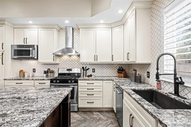 a kitchen with granite countertop a stove a sink and a microwave