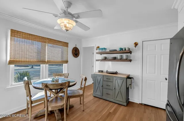 a view of a dining room with furniture a chandelier and wooden floor
