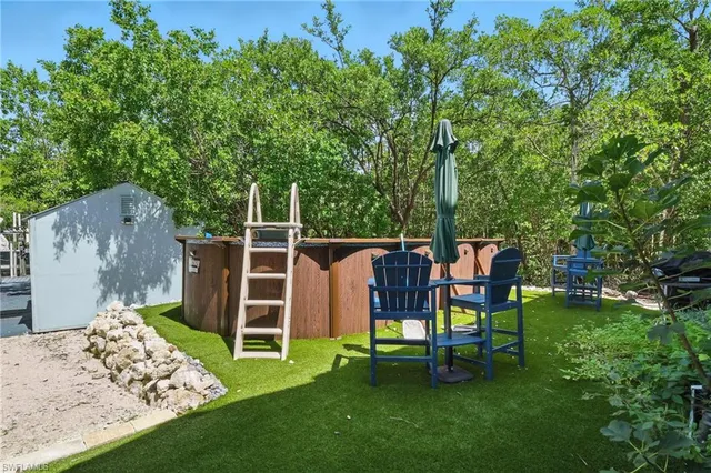 a view of a chair and table in backyard of the house