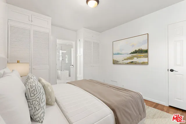 a bedroom with a bed and a painting on the wall