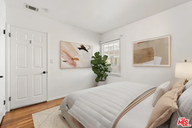 a bedroom with a bed and a painting on the wall