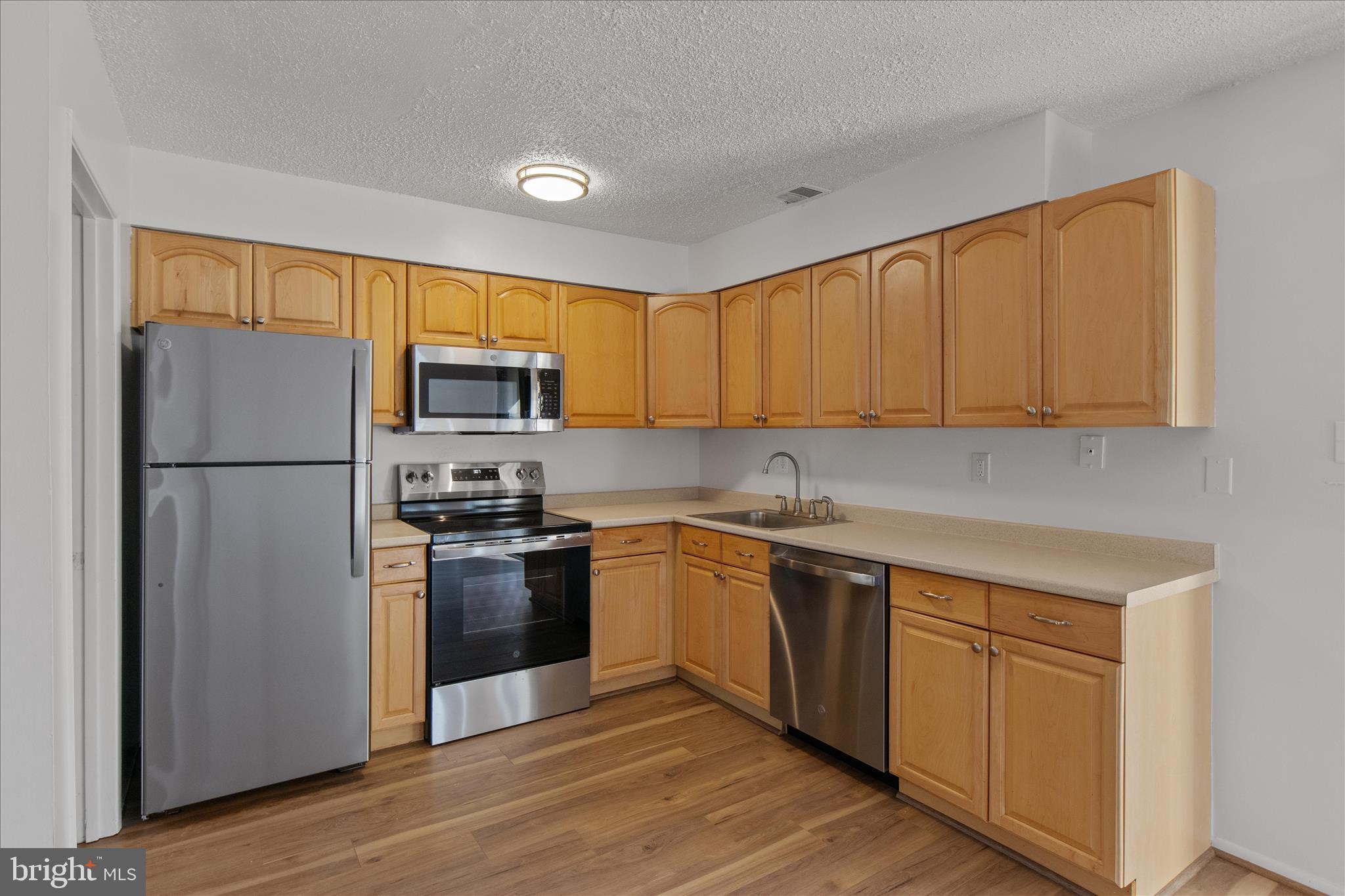 2142 Cartwright Place Reston, VA 20191 - Photo 4 of 29 a kitchen with stainless steel appliances granite countertop a refrigerator stove top oven and sink