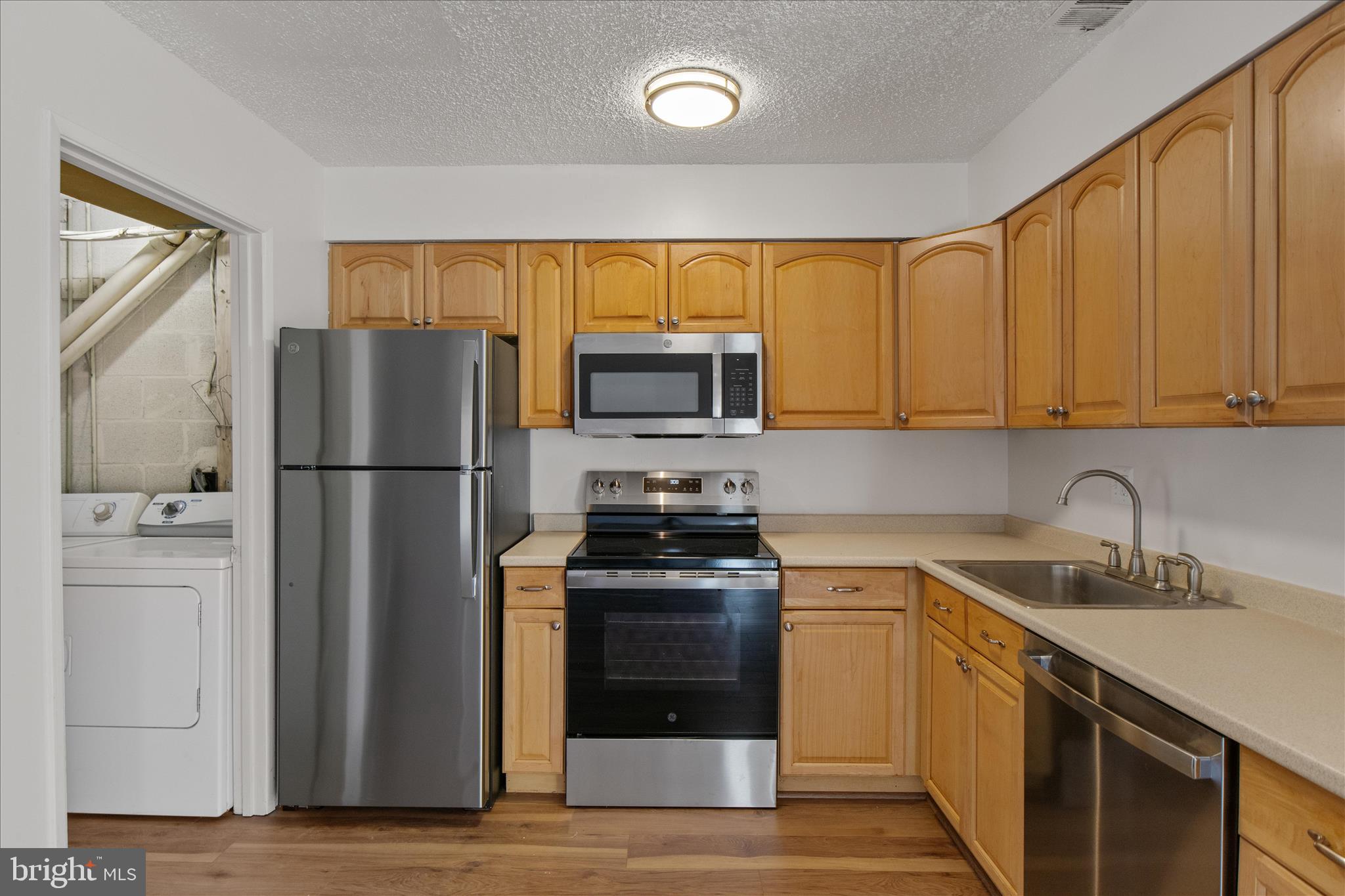 2142 Cartwright Place Reston, VA 20191 - Photo 10 of 29 a kitchen with white cabinets and stainless steel appliances