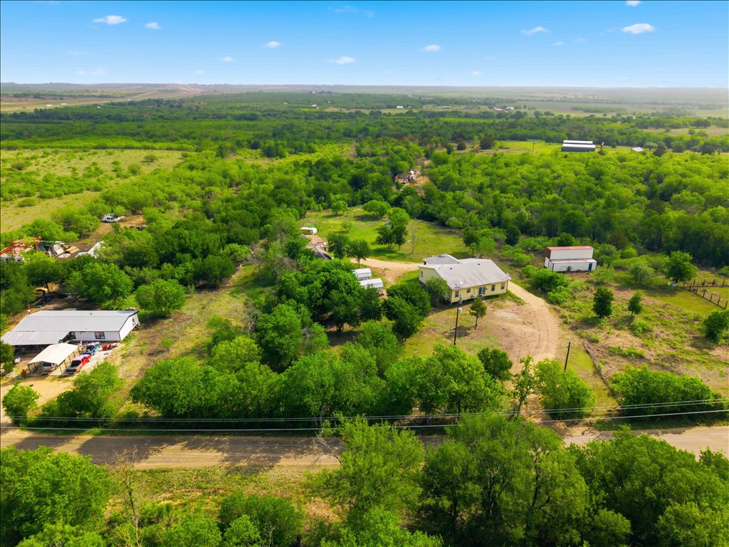 an aerial view of residential houses with outdoor space and trees