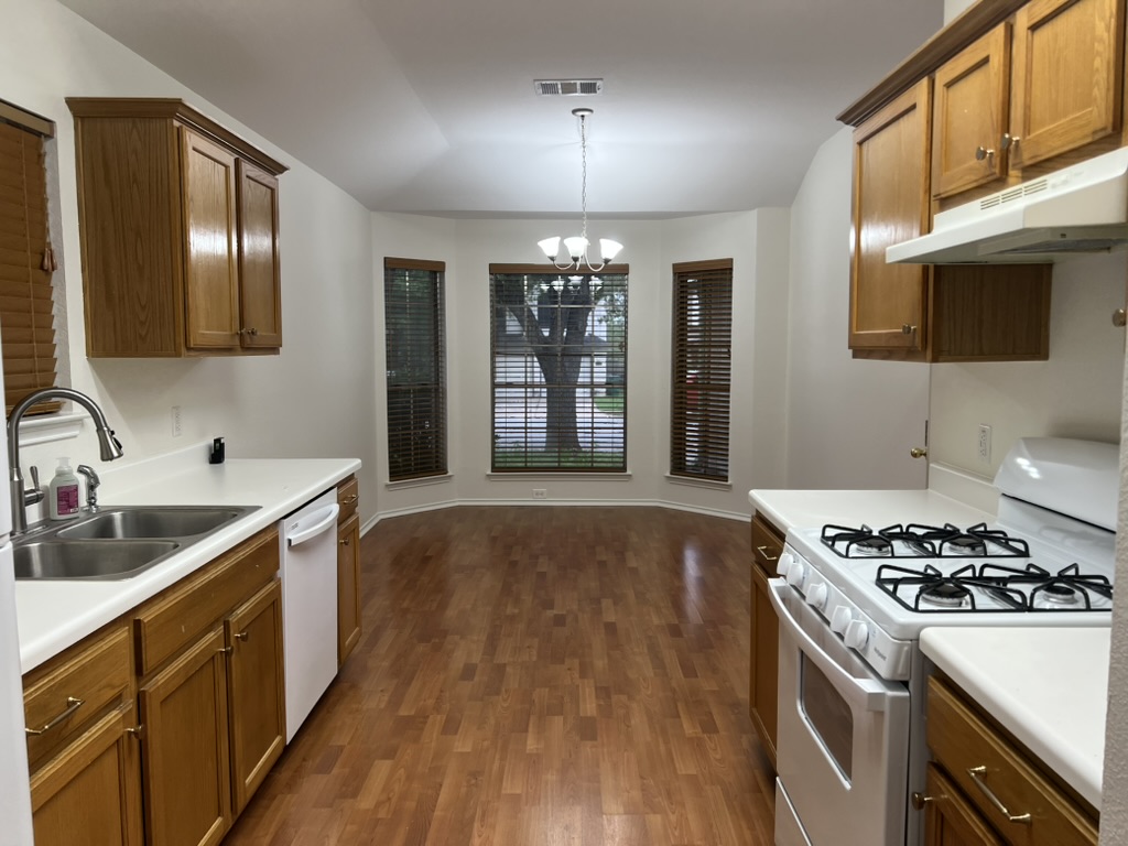 17843 Loch Linnhe Loop Pflugerville, TX 78660 - Photo 13 of 23 a kitchen with stainless steel appliances granite countertop a sink stove and refrigerator