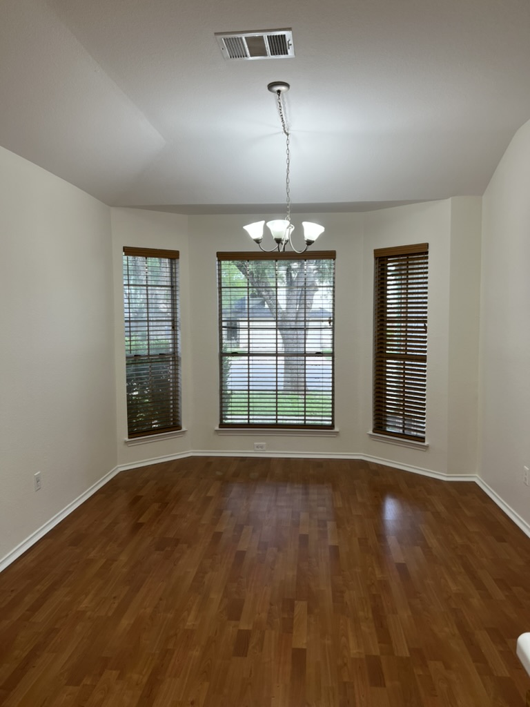 17843 Loch Linnhe Loop Pflugerville, TX 78660 - Photo 15 of 23 an empty room with wooden floor and windows