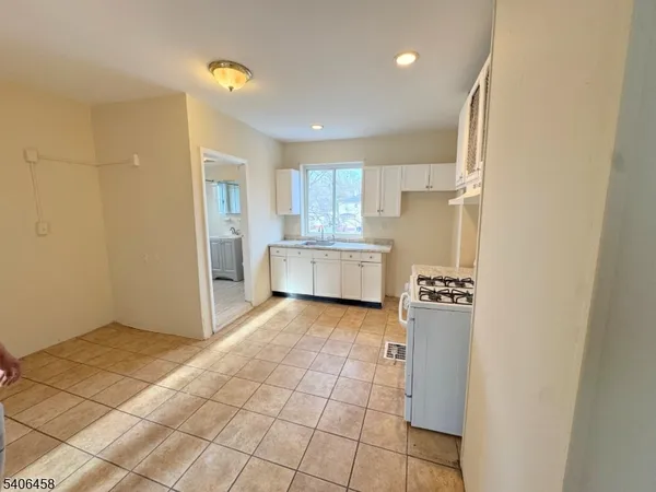 a kitchen with granite countertop a refrigerator and a stove top oven
