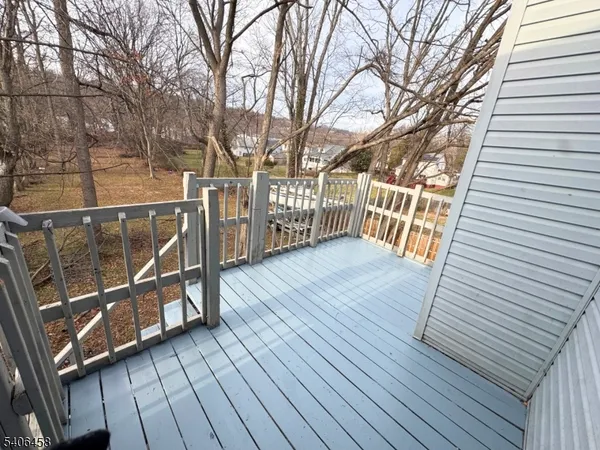 a view of a balcony with wooden floor and fence and a bench