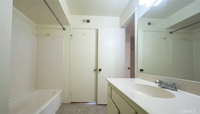 a bathroom with a granite countertop sink a mirror and a bathtub