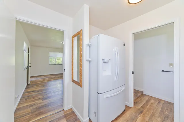 a view of a hallway with wooden floor and closet
