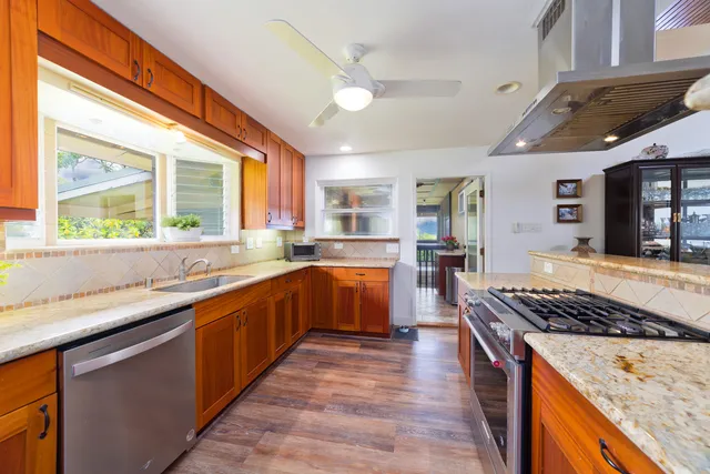 a kitchen with stainless steel appliances granite countertop a stove a sink and a microwave