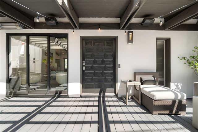 a view of a balcony with couch and chairs