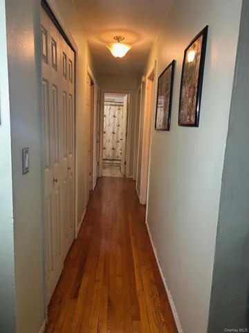 a view of a hallway with wooden floor