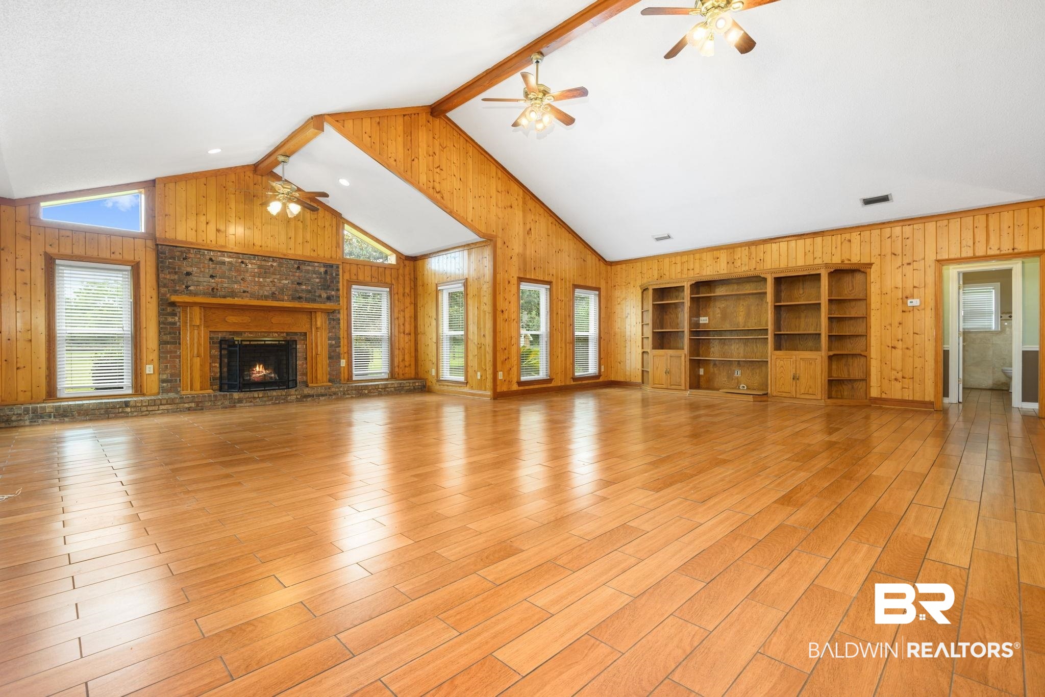 7540 2 Mile Road Irvington, AL 36544 - Photo 13 of 82 Spacious room featuring wood-finish flooring and a vaulted ceiling with exposed wood beams