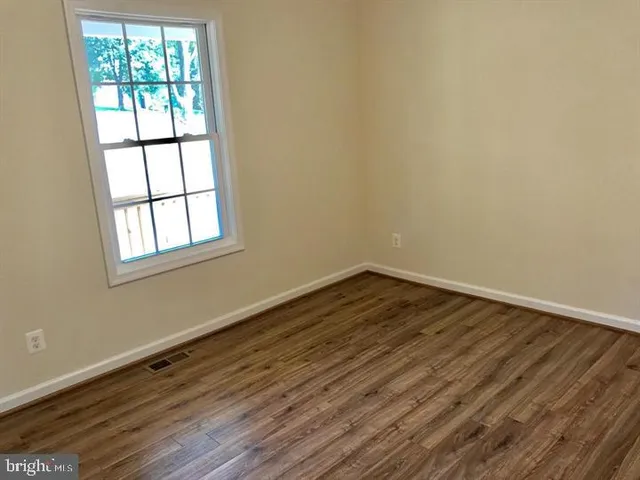 a view of a room with wooden floor and windows
