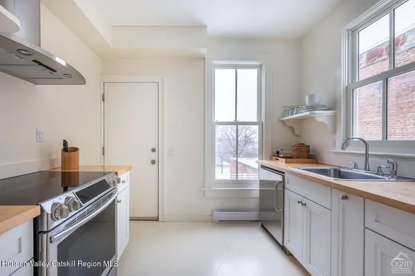 a kitchen with a sink appliances cabinets and a window