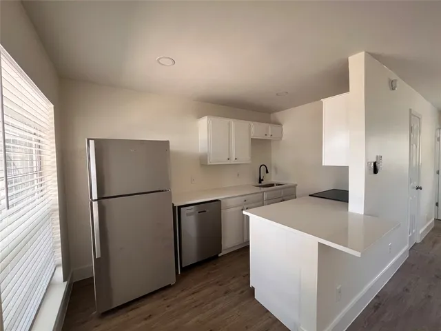 a kitchen with a refrigerator sink stove and cabinets