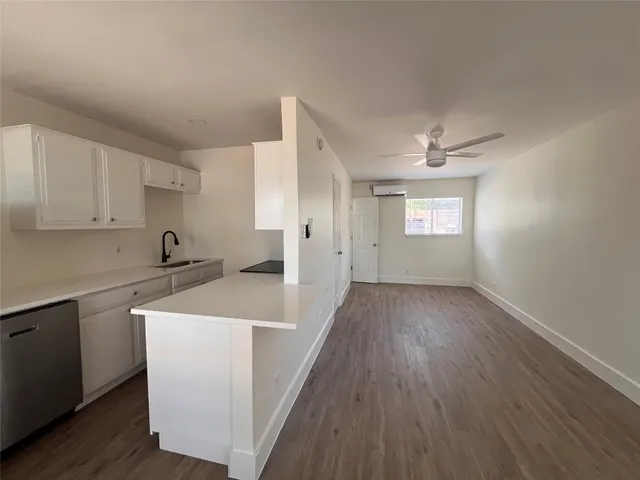 a view of a kitchen with wooden floor and electronic appliances