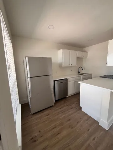 a kitchen with a refrigerator a sink and a stove top oven
