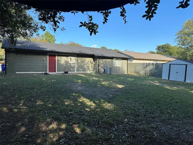 a view of a house with a yard and large tree