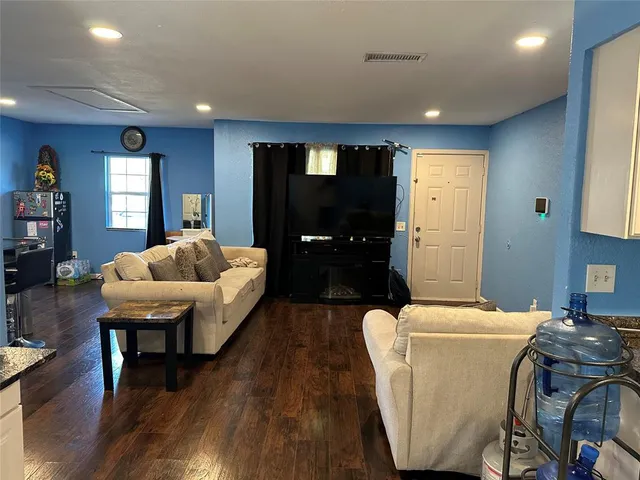 a living room with furniture and wooden floor
