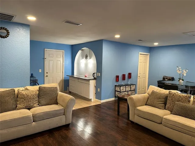 a living room with furniture and a wooden floor