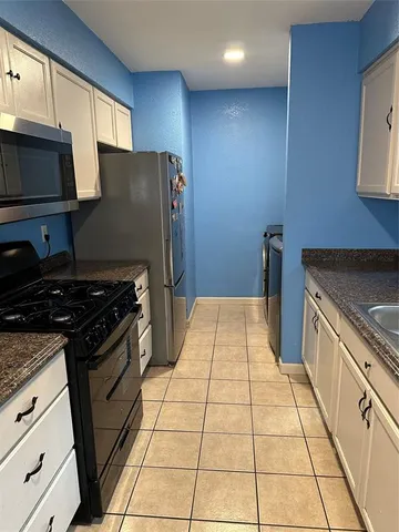 a kitchen with granite countertop a stove and a refrigerator