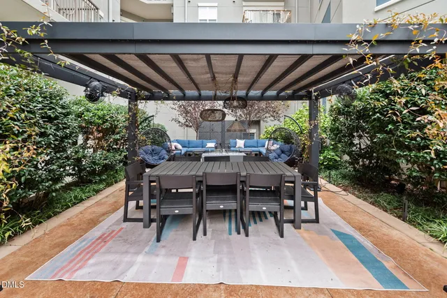 a view of a patio with couches table and chairs and potted plants