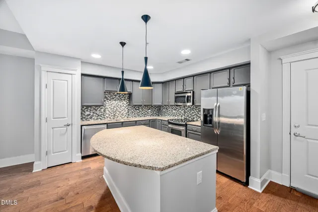 a kitchen with stainless steel appliances granite countertop a refrigerator and a sink