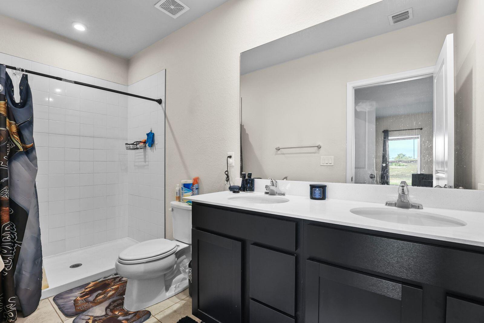 185 Dabou Loop Belle Glade, FL 33430 - Photo 12 of 25 a bathroom with a sink toilet vanity and shower