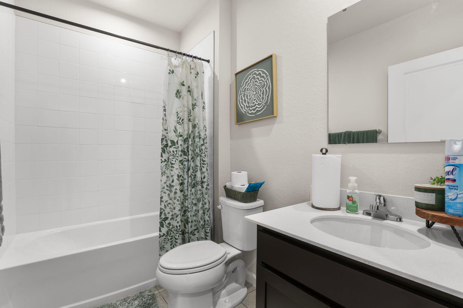 185 Dabou Loop Belle Glade, FL 33430 - Photo 19 of 25 a bathroom with a sink a toilet and shower curtain