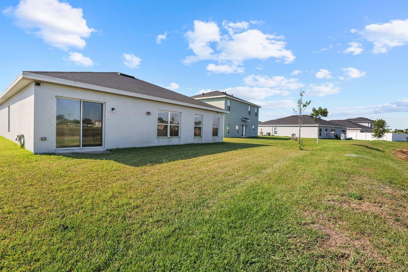 185 Dabou Loop Belle Glade, FL 33430 - Photo 21 of 25 a view of a house with a yard
