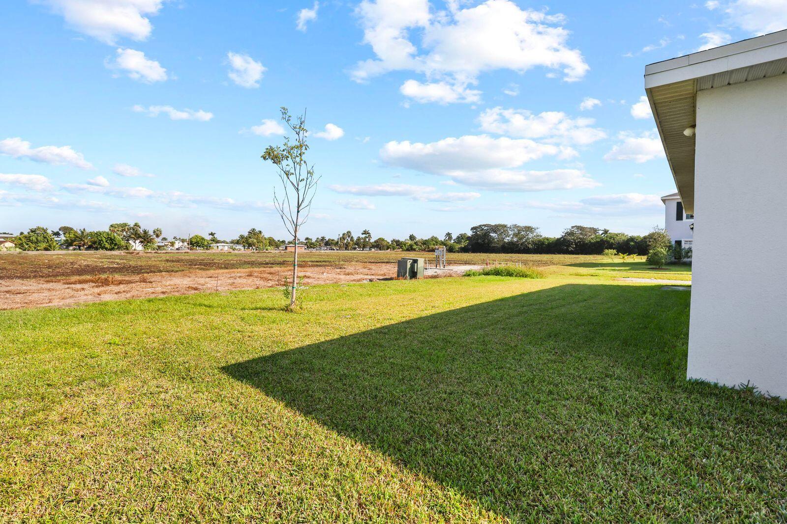 185 Dabou Loop Belle Glade, FL 33430 - Photo 22 of 25 a view of a lake with a big yard