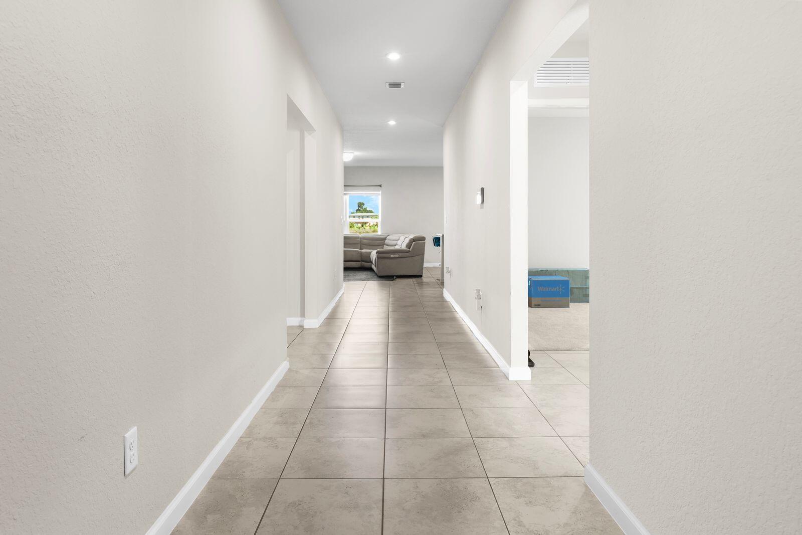 185 Dabou Loop Belle Glade, FL 33430 - Photo 3 of 25 a view of a hallway with a couch and a potted plant