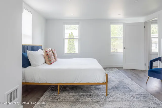a bedroom with a bed and a view of living room