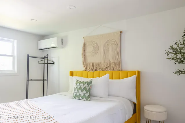 a bedroom with a bed and painting on the wall