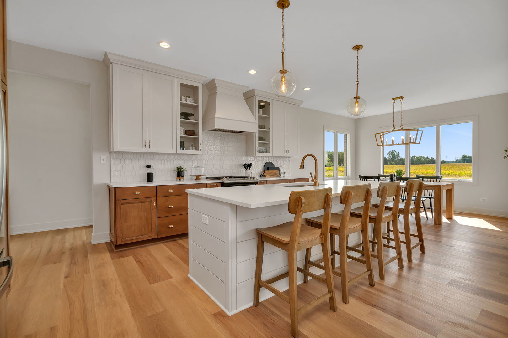 1074 Kinley Drive New Lenox, IL 60451 - Photo 6 of 37 a kitchen with stainless steel appliances kitchen island granite countertop a table chairs sink and cabinets