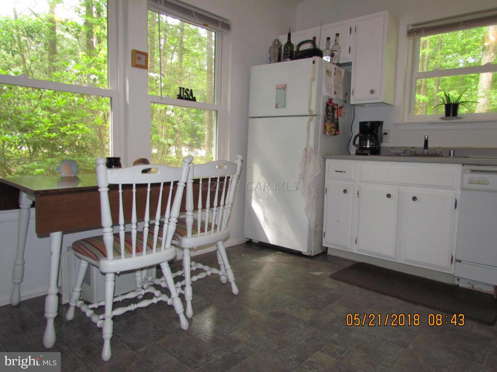 38 Sandyhook Road Ocean Pines, MD 21811 - Photo 12 of 33 a kitchen with a refrigerator a stove a sink and a dining table with wooden floor